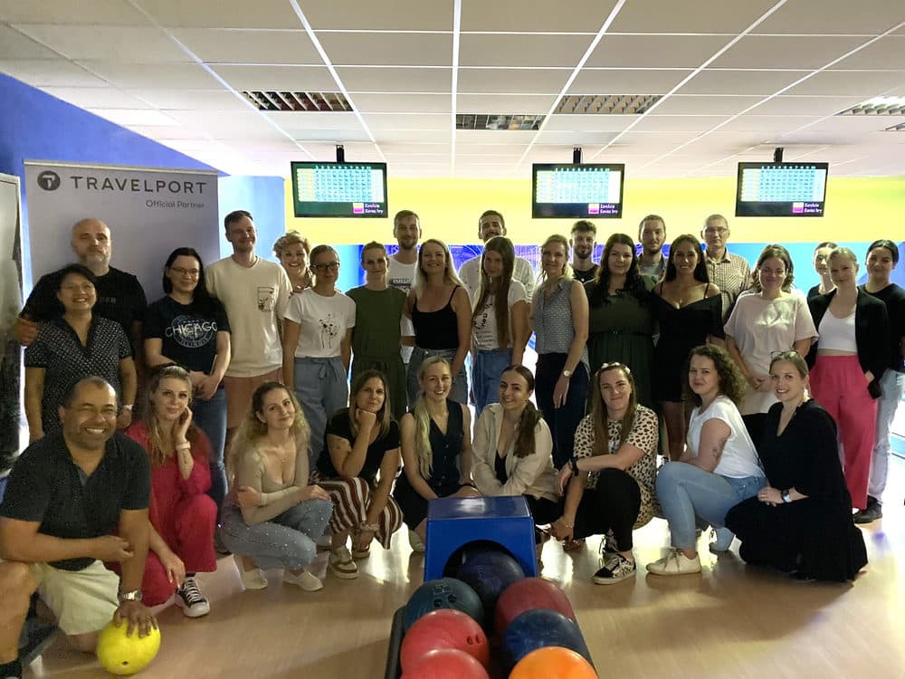 Účastníci bowlingového setkání ve Zvolenu 2024 v herně s bannerem Travelport